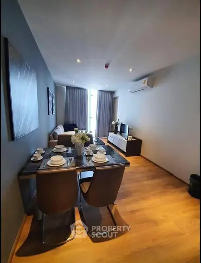Modern living room with dining area, stylish decor, and wooden flooring in a cozy apartment.