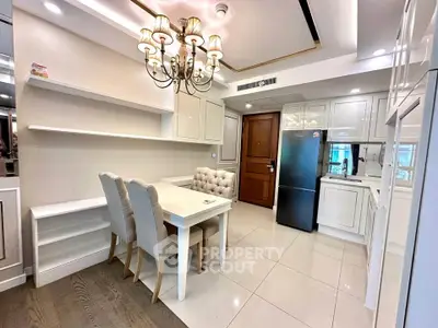 Elegant dining area with chandelier and modern kitchen in a stylish apartment.