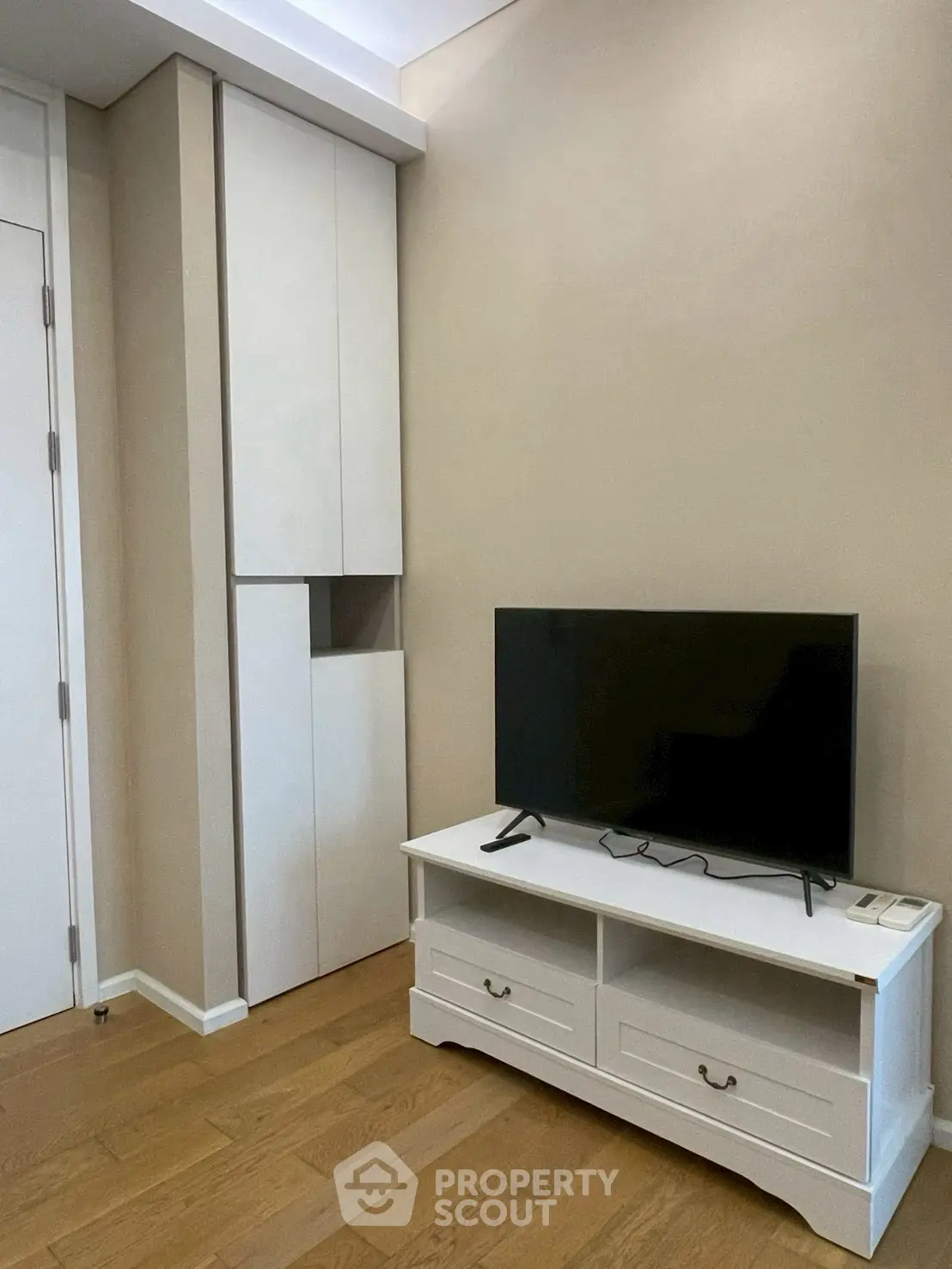 Modern living room with sleek TV stand and built-in storage, featuring elegant wooden flooring.