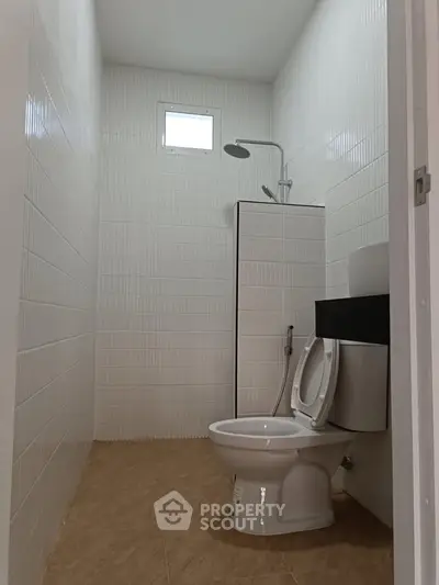 Compact bathroom with modern shower and toilet in a minimalist design.