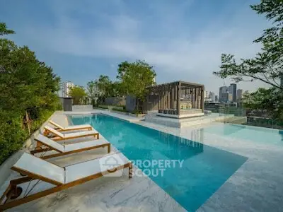 Luxurious rooftop pool with city skyline view and elegant lounge chairs.