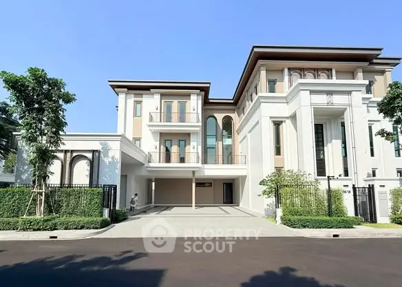 Luxurious modern three-story house with elegant facade and spacious driveway in a serene neighborhood.