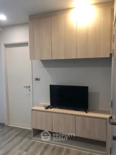 Modern living room with sleek wooden TV cabinet and mounted storage.