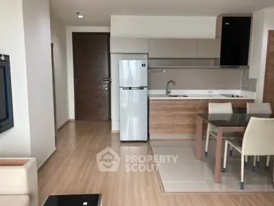 Modern open-layout kitchen with dining area and sleek appliances in a stylish apartment.