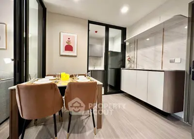 Modern dining area with elegant chairs and open kitchen layout in a stylish apartment.