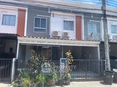Charming townhouse exterior with modern facade and lush plants, perfect for urban living.