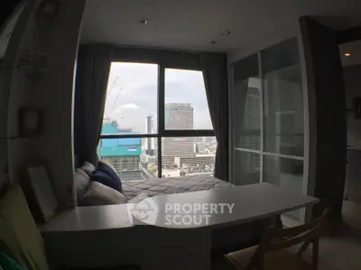 Modern urban apartment with stunning city view from large window, featuring cozy seating and sleek furnishings.