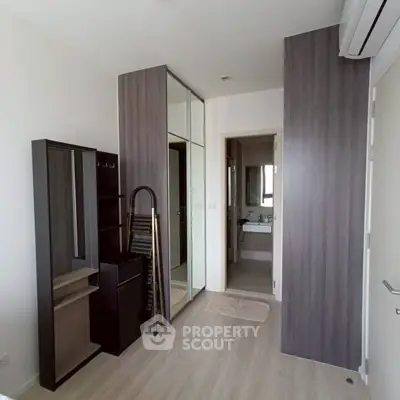 Modern bedroom with sleek storage and ensuite bathroom in a stylish apartment.