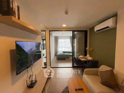 Modern living room with open layout, stylish furniture, and a view into a cozy bedroom.