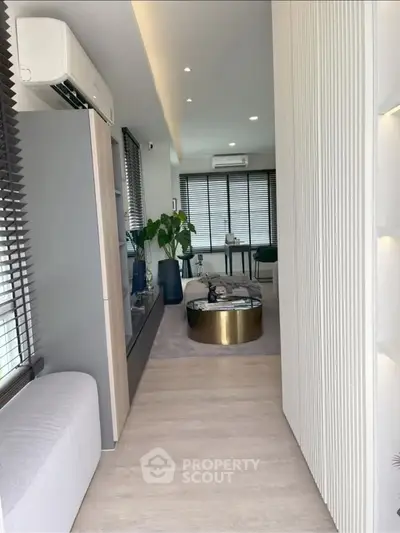 Modern living room with sleek design and natural light, featuring stylish furniture and decor.