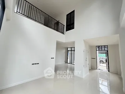 Spacious modern living room with high ceilings and large windows, perfect for natural light.