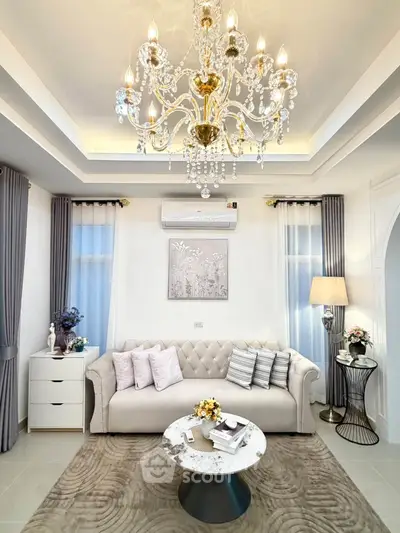 Luxurious living room with elegant chandelier and plush sofa, perfect for sophisticated living.