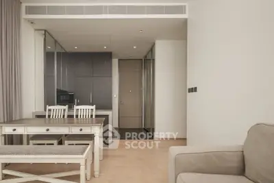 Modern open-plan living room with elegant dining area and sleek kitchen cabinetry.