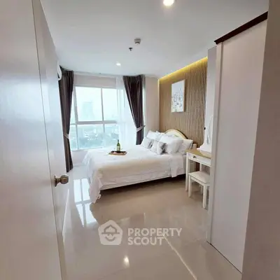 Modern bedroom with city view, elegant decor, and natural light.