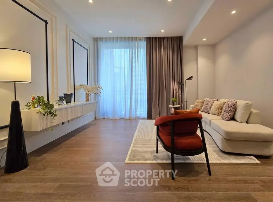 Elegant living room with modern decor and large window for natural light.