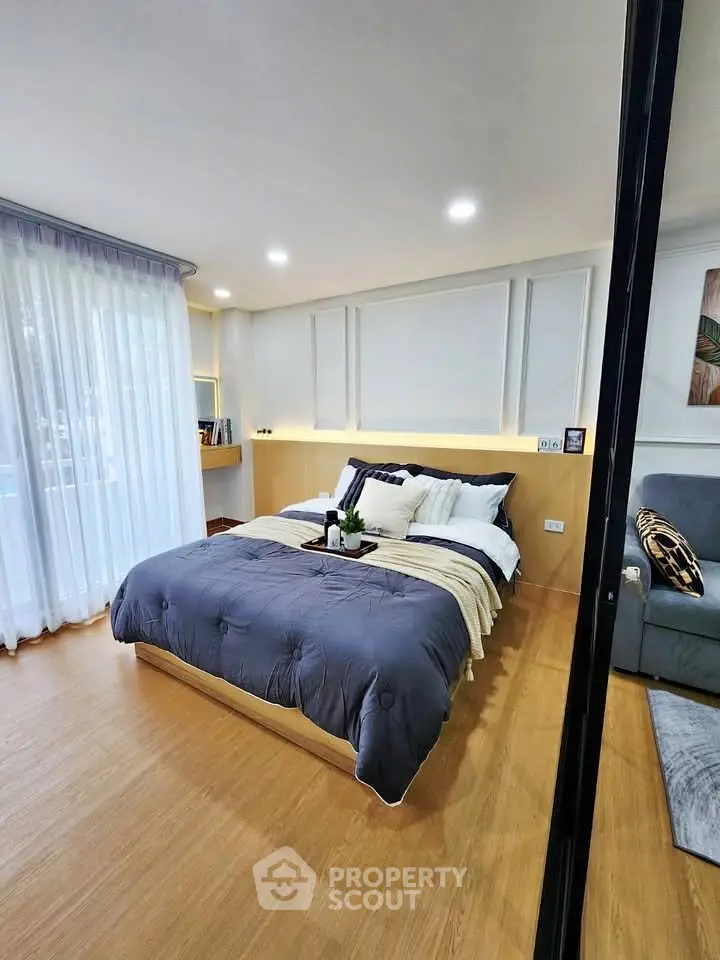 Modern bedroom with cozy bedding and elegant decor in a stylish apartment.