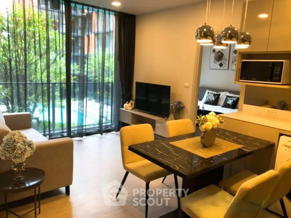 Modern living room with dining area and pool view, featuring elegant decor and natural light.