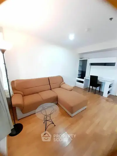 Modern living room with cozy brown sectional sofa and sleek white desk.