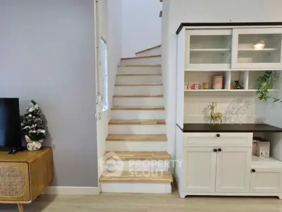 Charming interior with wooden staircase and stylish cabinet, perfect for cozy living.