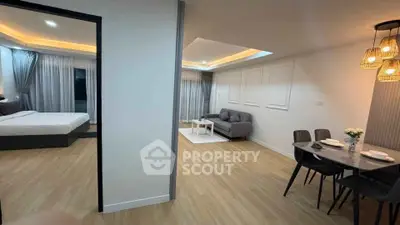 Modern open-plan living room and dining area with stylish decor and wooden flooring.