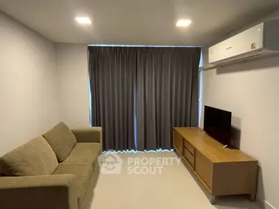 Modern living room with cozy sofa, sleek TV stand, and air conditioning for comfort.