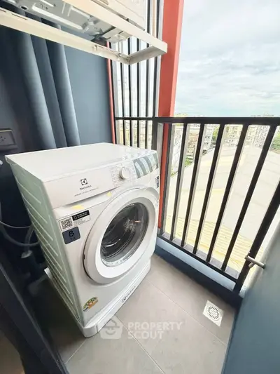 Compact balcony with washing machine and city view, perfect for urban living convenience.