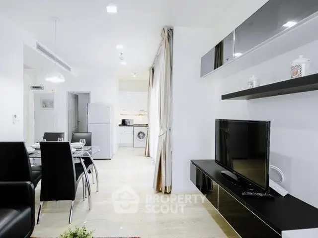 Modern open-plan living room with sleek furniture and integrated kitchen appliances.