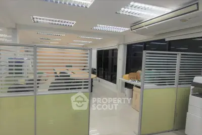 Spacious office space with modern lighting and partitioned workstations, ideal for productivity and collaboration.