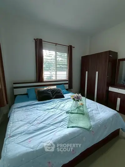 Cozy bedroom with large bed and stylish wardrobe, perfect for relaxation.