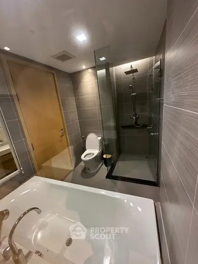 Modern bathroom with glass shower, bathtub, and sleek design