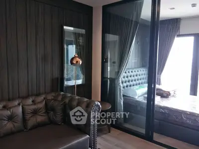Luxurious modern living room with leather sofa and glass partition to bedroom