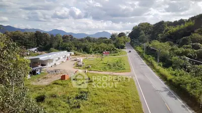 Scenic rural road with lush greenery and distant mountains, ideal for serene living.