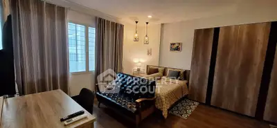 Cozy bedroom with stylish decor and natural light, featuring a comfortable bed and modern furnishings.