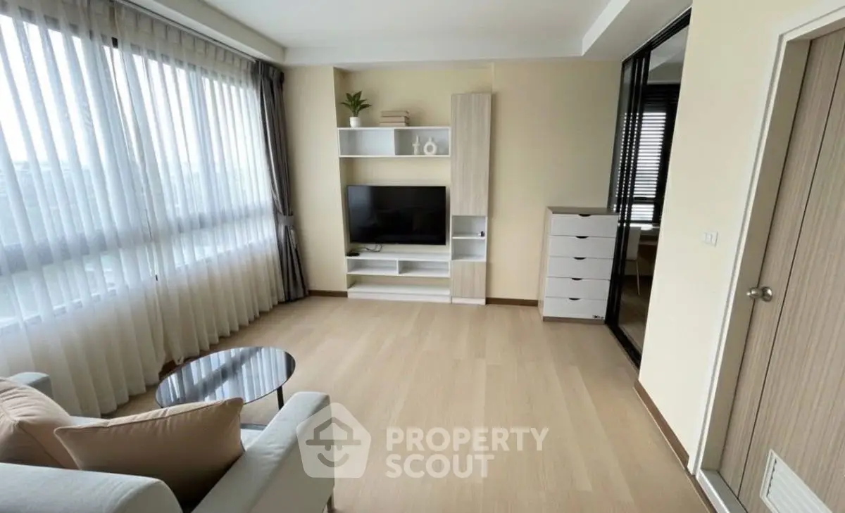 Spacious living room with modern decor and large windows for natural light.