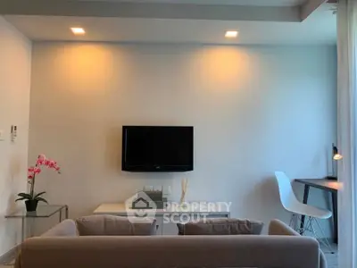 Modern living room with sleek furniture and wall-mounted TV, perfect for relaxation and entertainment.