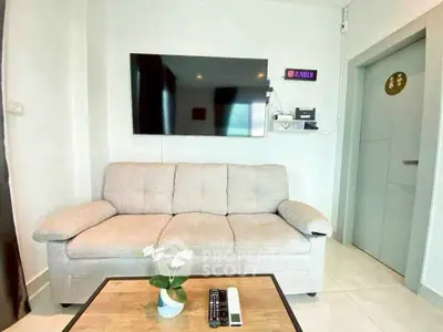 Modern living room with cozy sofa and wall-mounted TV, perfect for relaxation.