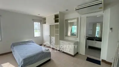 Spacious bedroom with built-in wardrobe and air conditioning in modern apartment.