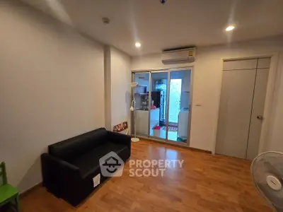 Spacious living room with modern decor and wooden flooring in a cozy apartment.