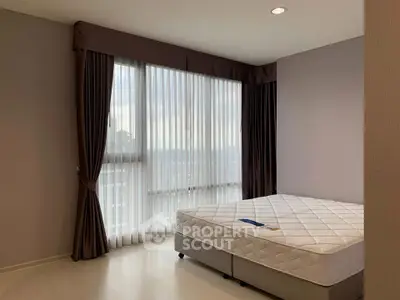 Spacious bedroom with large window and elegant curtains in modern apartment
