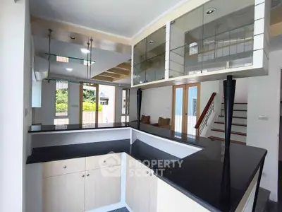 Modern kitchen with sleek black countertops and open layout in a bright home interior.