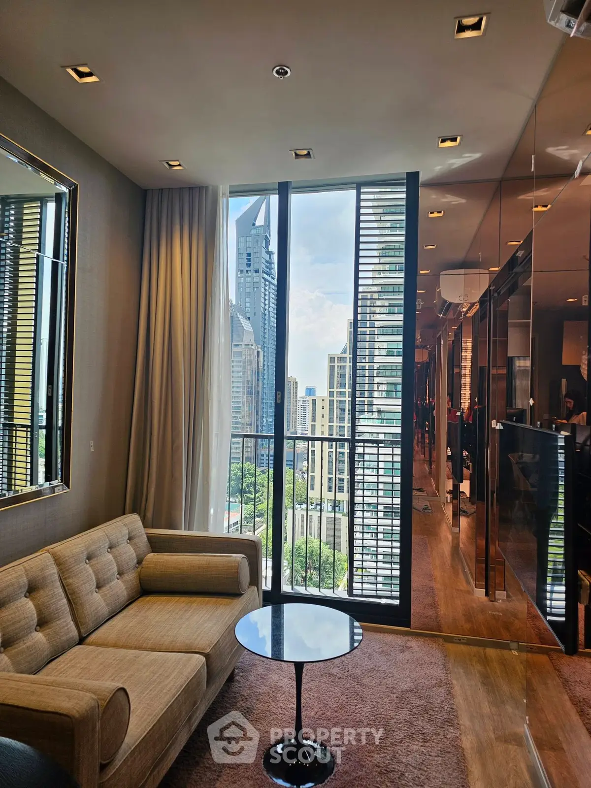 Luxurious living room with city view, featuring modern sofa and sleek glass doors.