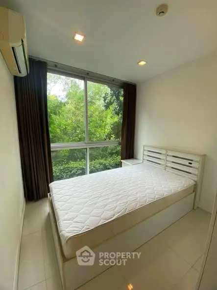 Bright bedroom with large window and lush green view