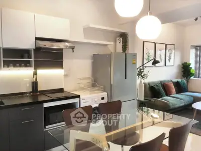 Modern open-layout kitchen and living room with sleek appliances and stylish decor.