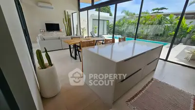 Modern open-plan living room with pool view and sleek kitchen island