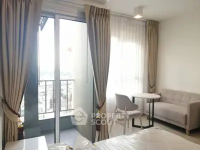 Bright bedroom with balcony view, featuring modern furniture and elegant curtains.