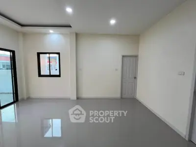 Spacious modern living room with sleek flooring and ample natural light.