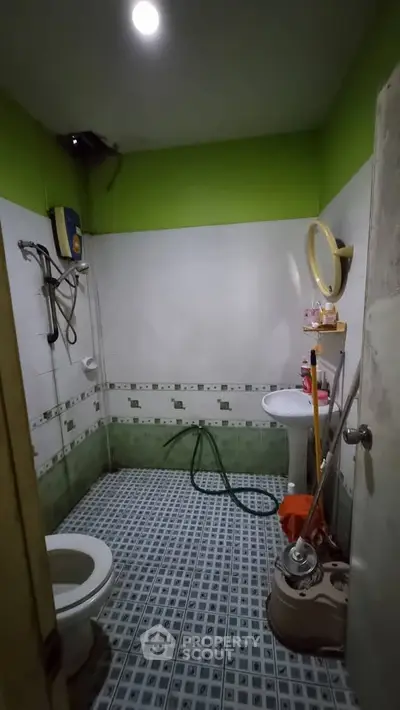 Cozy bathroom with green accents and modern fixtures, perfect for a refreshing start to your day.