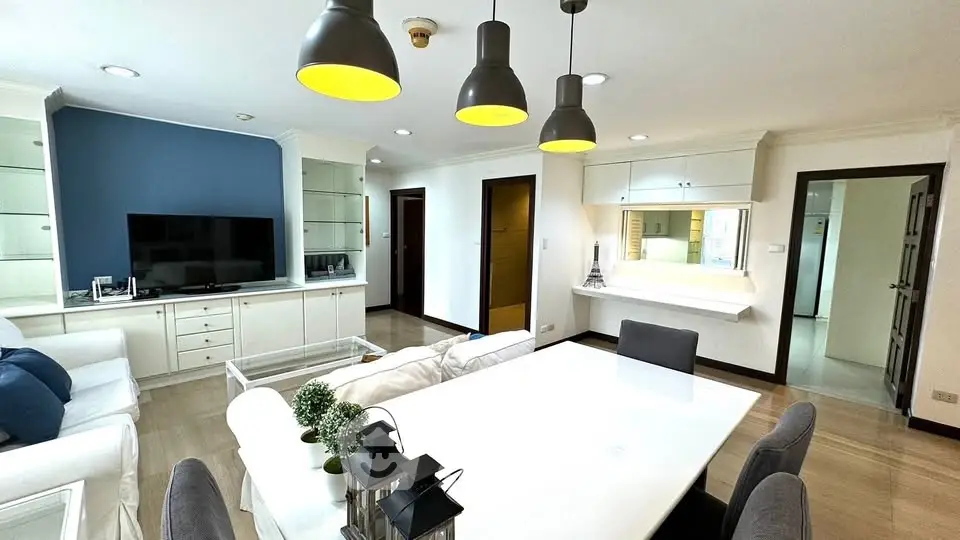 Spacious modern living room with elegant dining area and stylish lighting fixtures.