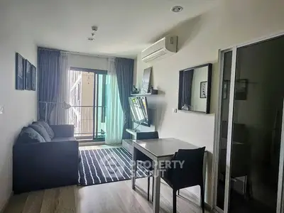 Modern living room with balcony access, featuring sleek furniture and natural light.