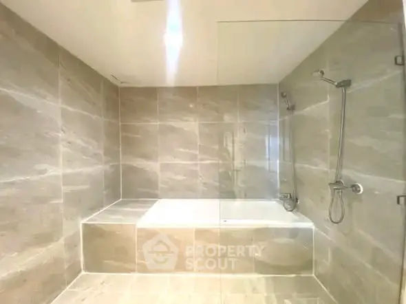 Luxurious modern bathroom with sleek marble tiles and a spacious bathtub.